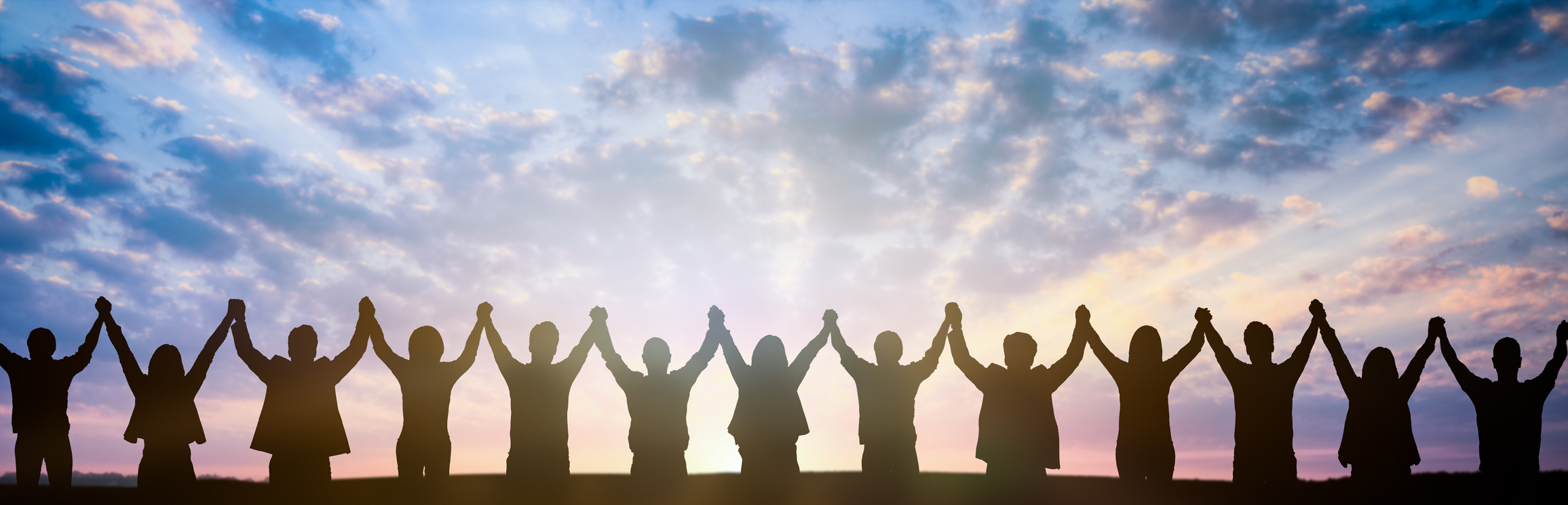 Silhouette of Business Team Holding Hands at Sunset